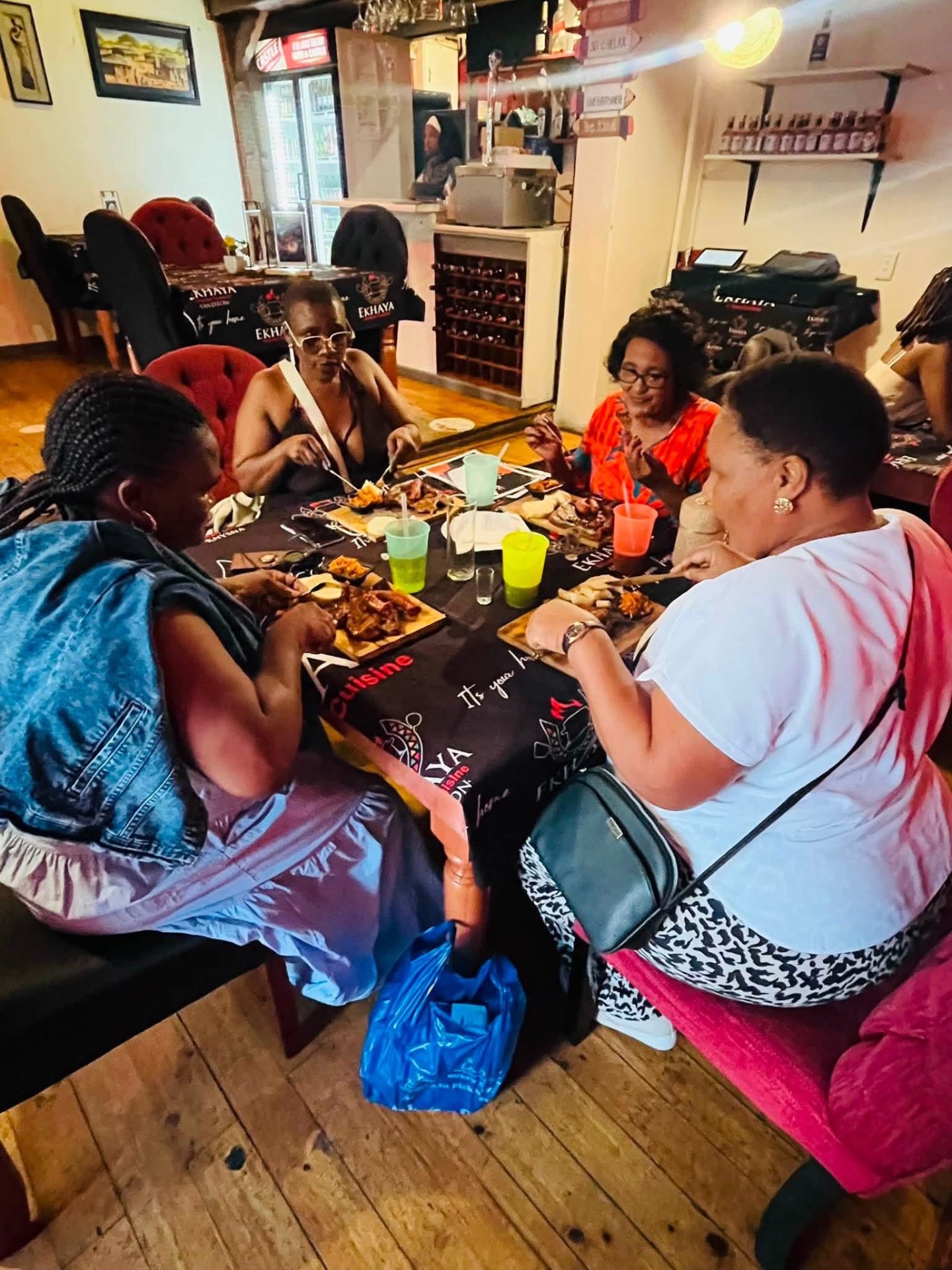 Ladies enjoying grilled platters inside Ekhaya