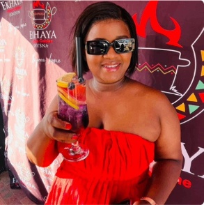 Woman raising a colourful Ekhaya cocktail