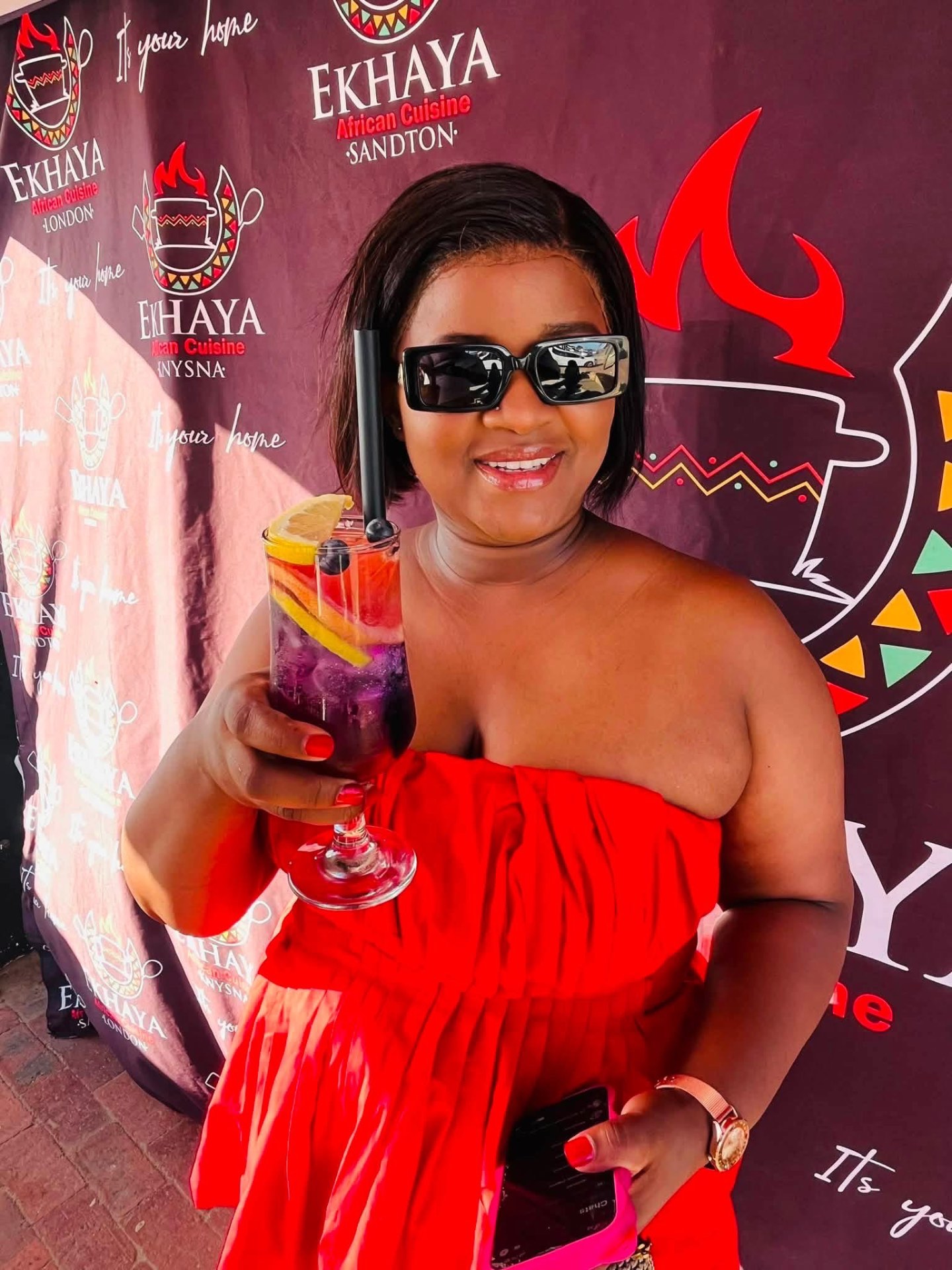 Guest posing with a signature Ekhaya cocktail