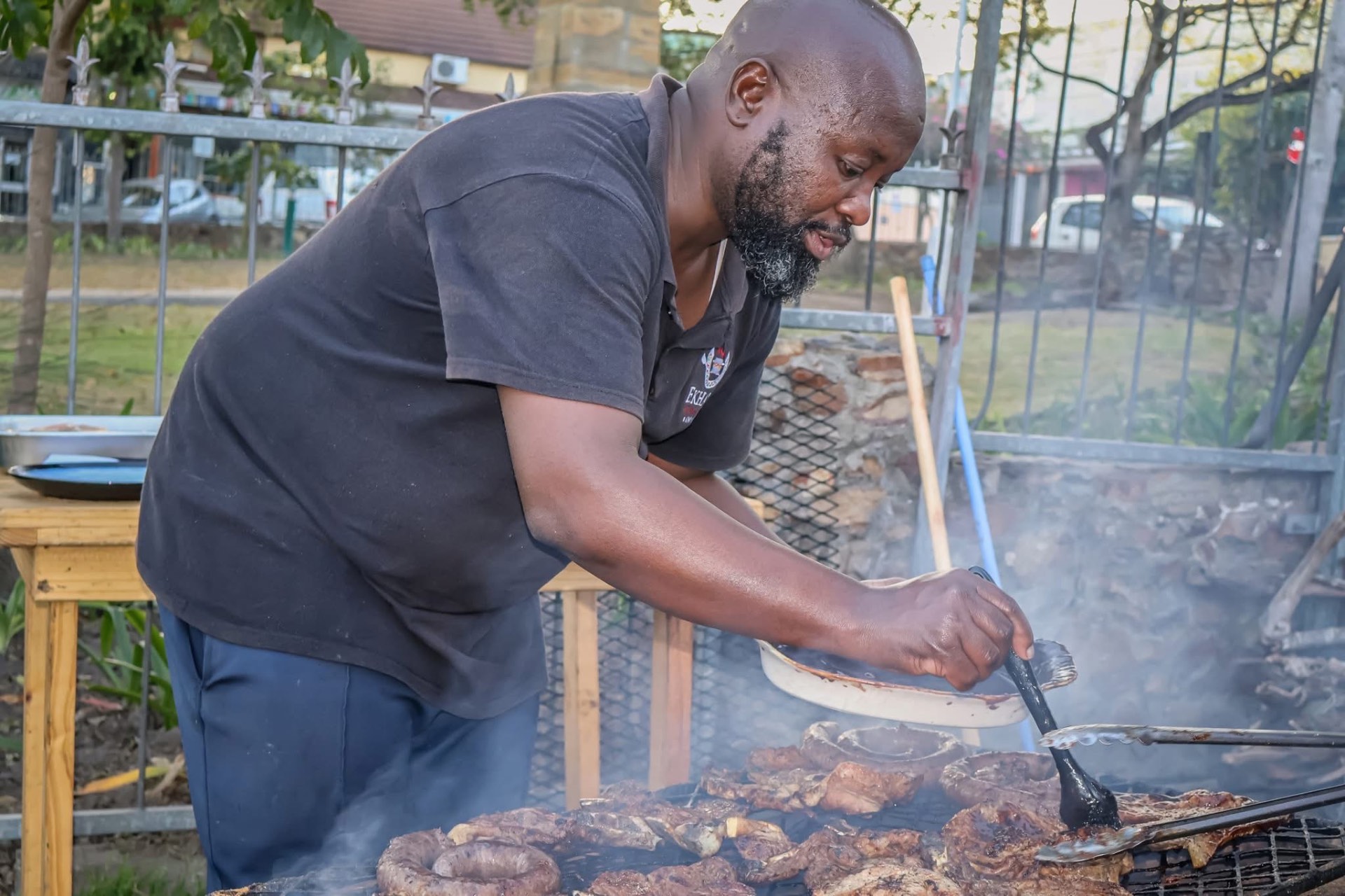 Chef Lulo grilling meat over the open braai fire every Sunday